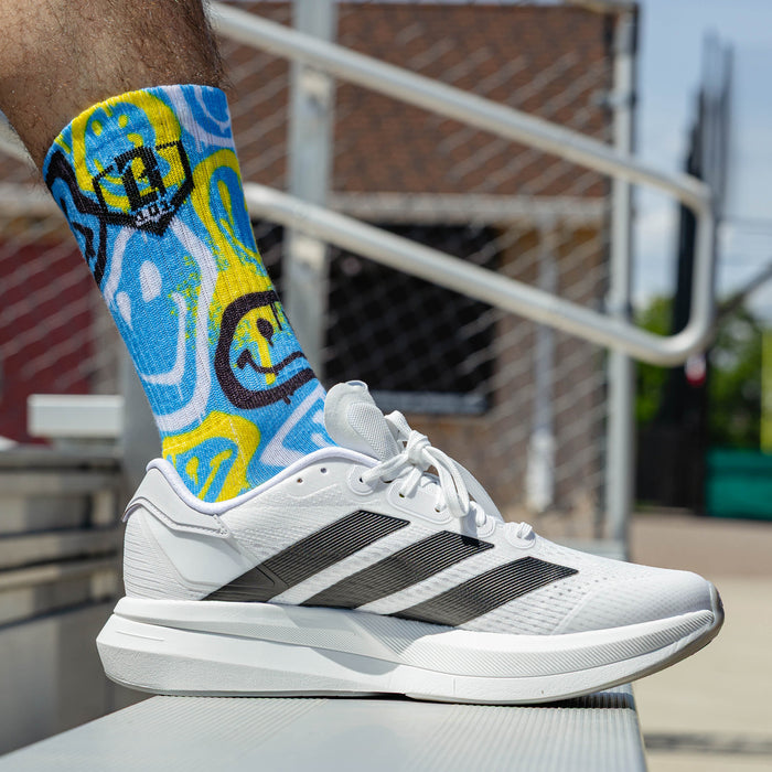 Adult model wearing multi-color socks with "Smiley Slugger Performance  3-Pack" design