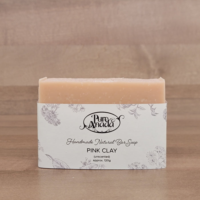 Bar of handmade unscented natural soap with packaging on a wooden surface