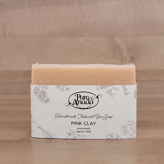 Bar of handmade unscented natural soap with packaging on a wooden surface