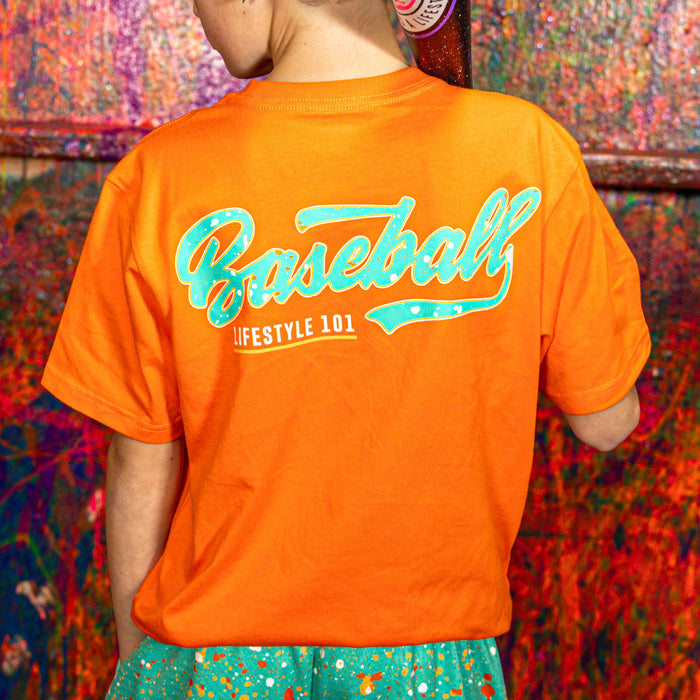Person wearing an orange t-shirt with a teal 'Baseball Lifestyle 101' text against a colorful background