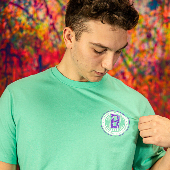 Person wearing a teal t-shirt with a BL101 logo against a colorful abstract background