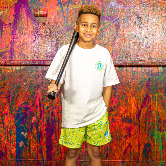 Child holding a baseball bat in front of a colorful, textured wall