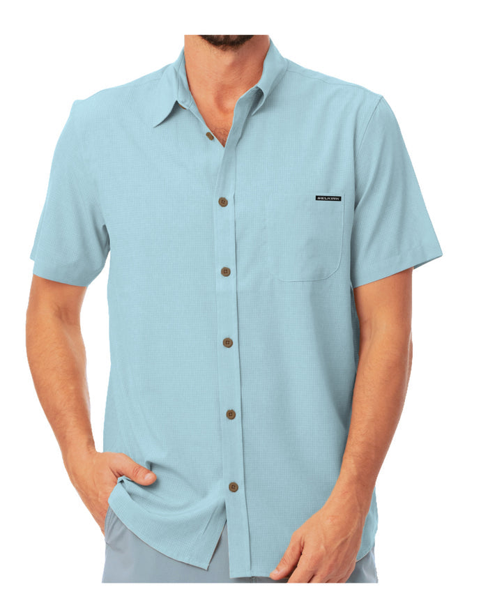Man wearing a light blue short sleeve button down shirt from the Selkirk Spring Owen Collection, front view with hands in pockets.