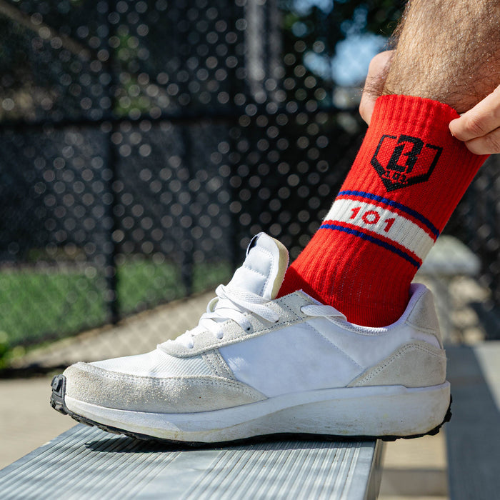 Adult model wearing red, white & blue socks with "Stadium Performance  3-Pack" design