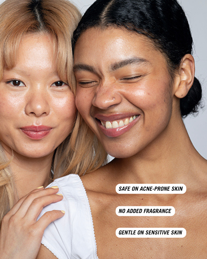 Two smiling women standing closely together. Text on the image reads: 'Safe on acne-prone skin', 'No added fragrance', and 'Gentle on sensitive skin'.