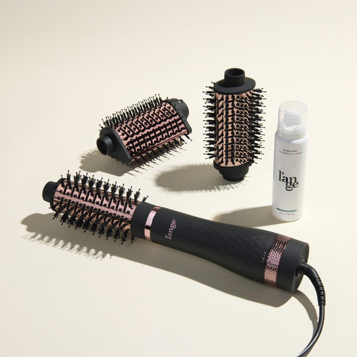 The Switch It Up Value Set, featuring a Black Multi-Volume Series Brush, 65mm and secondary attachments, and Glass Hair, displayed on a beige background.