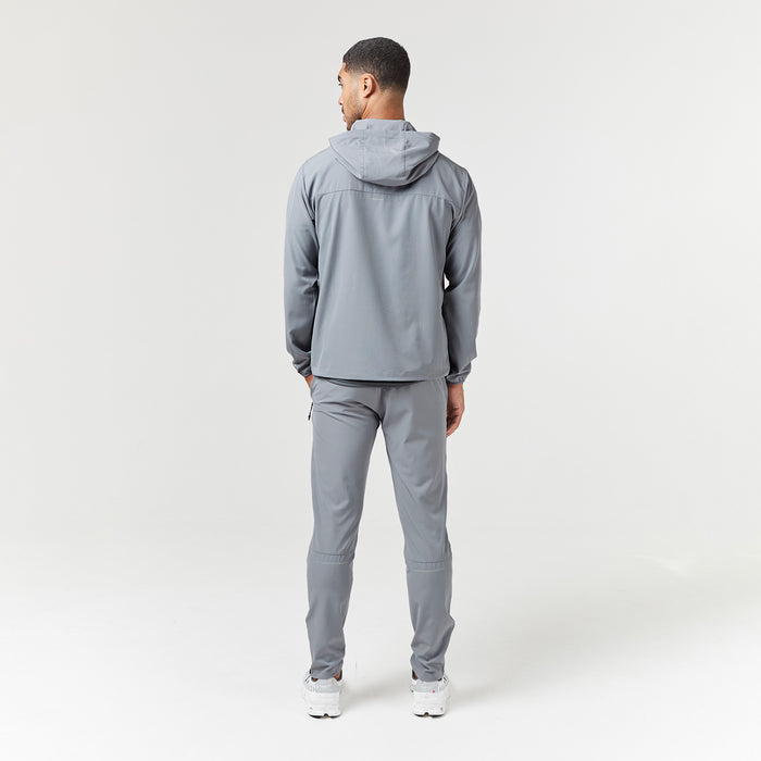 Back shot of male model wearing grey technical tracksuit with hood