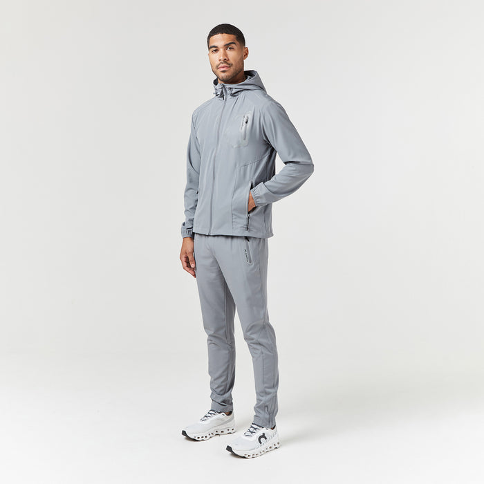 Male model wearing full grey technical tracksuit with hand in pocket