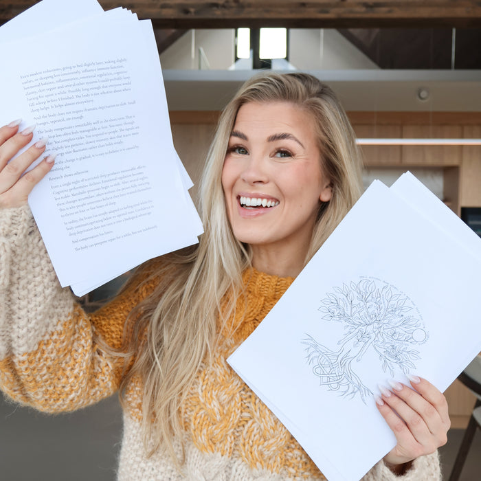Woman smiling and holding printed pages from 'The Frøya Way'