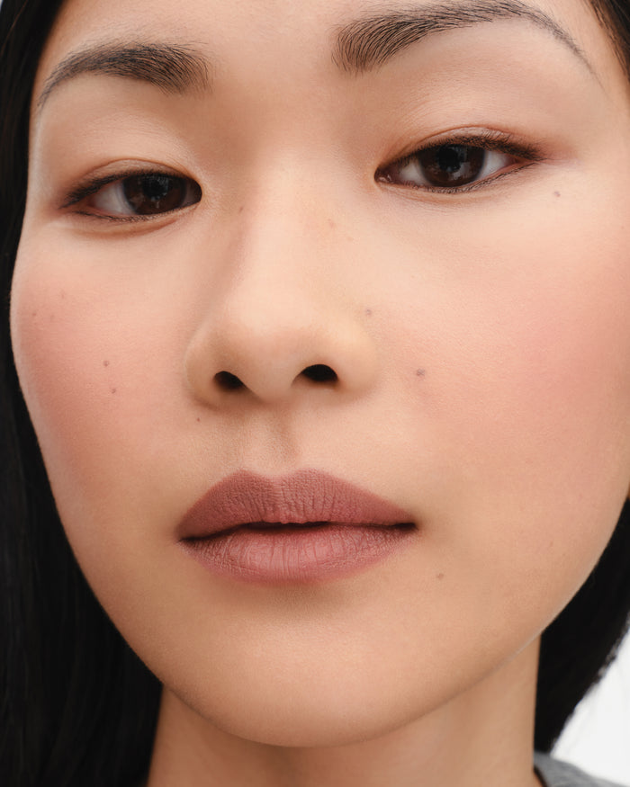 Model wears lipstick in shade Mimi.