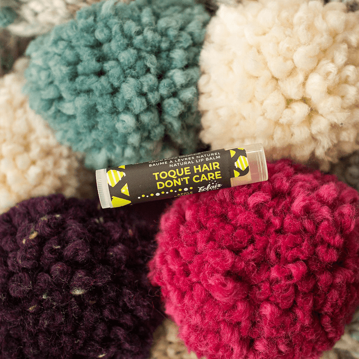 Toque Hair Don't Care lip balm on colorful pom poms