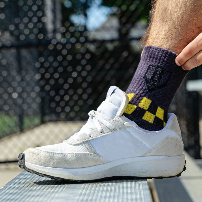 Adult model wearing green socks with "Warhawk Performance  3-Pack" design